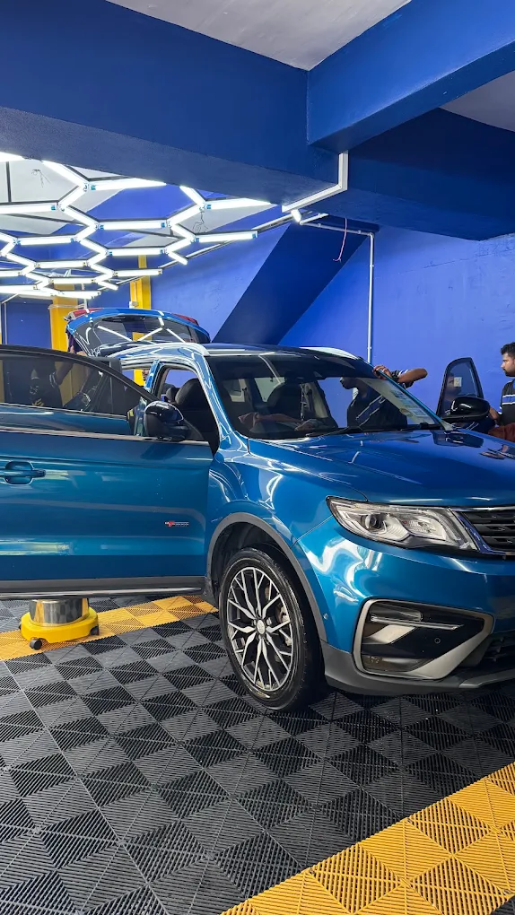 A blue SUV in the GVS Autospa bay under the hexagonal light rig