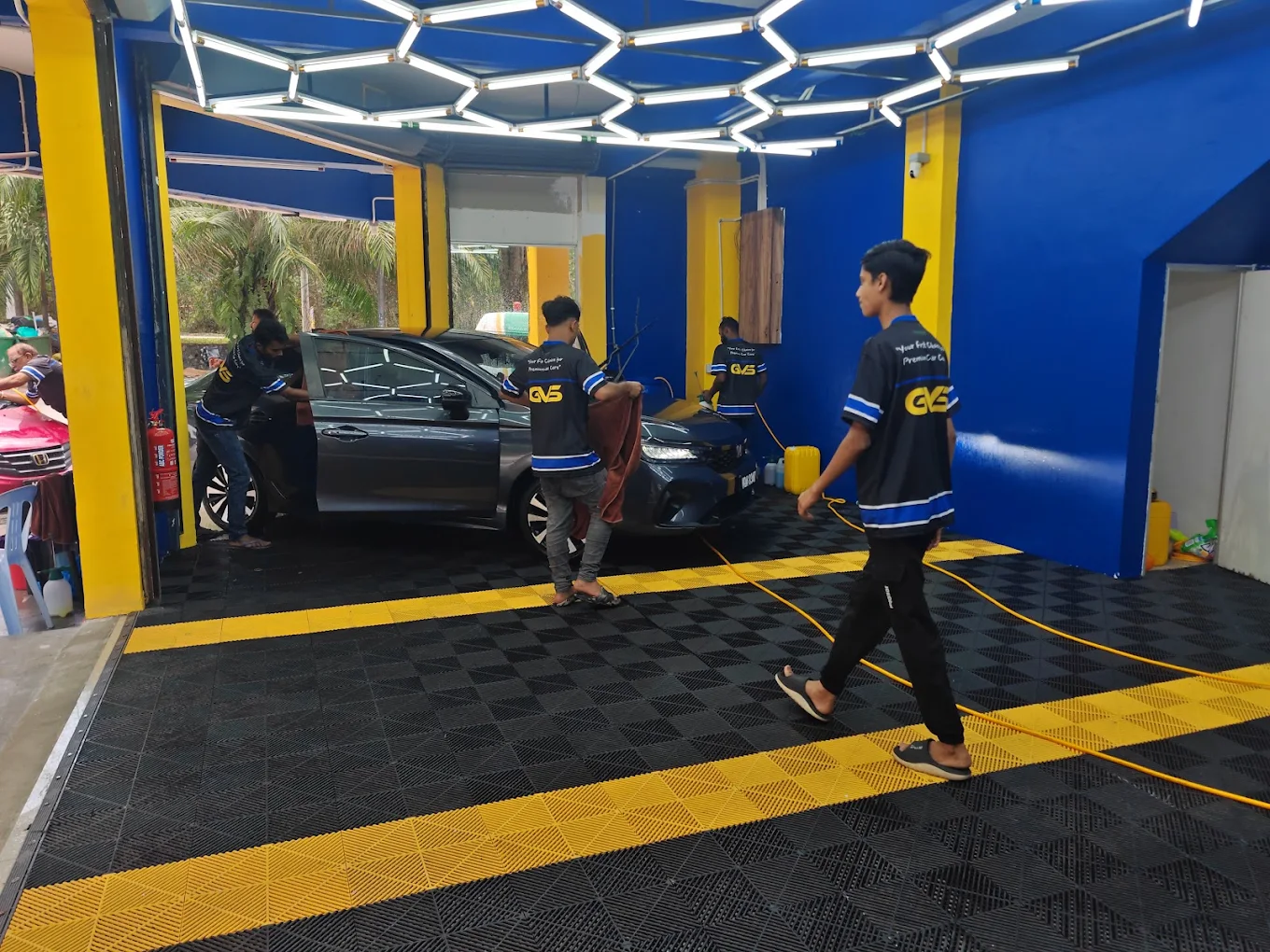 Crew members drying a car in the GVS Autospa bay