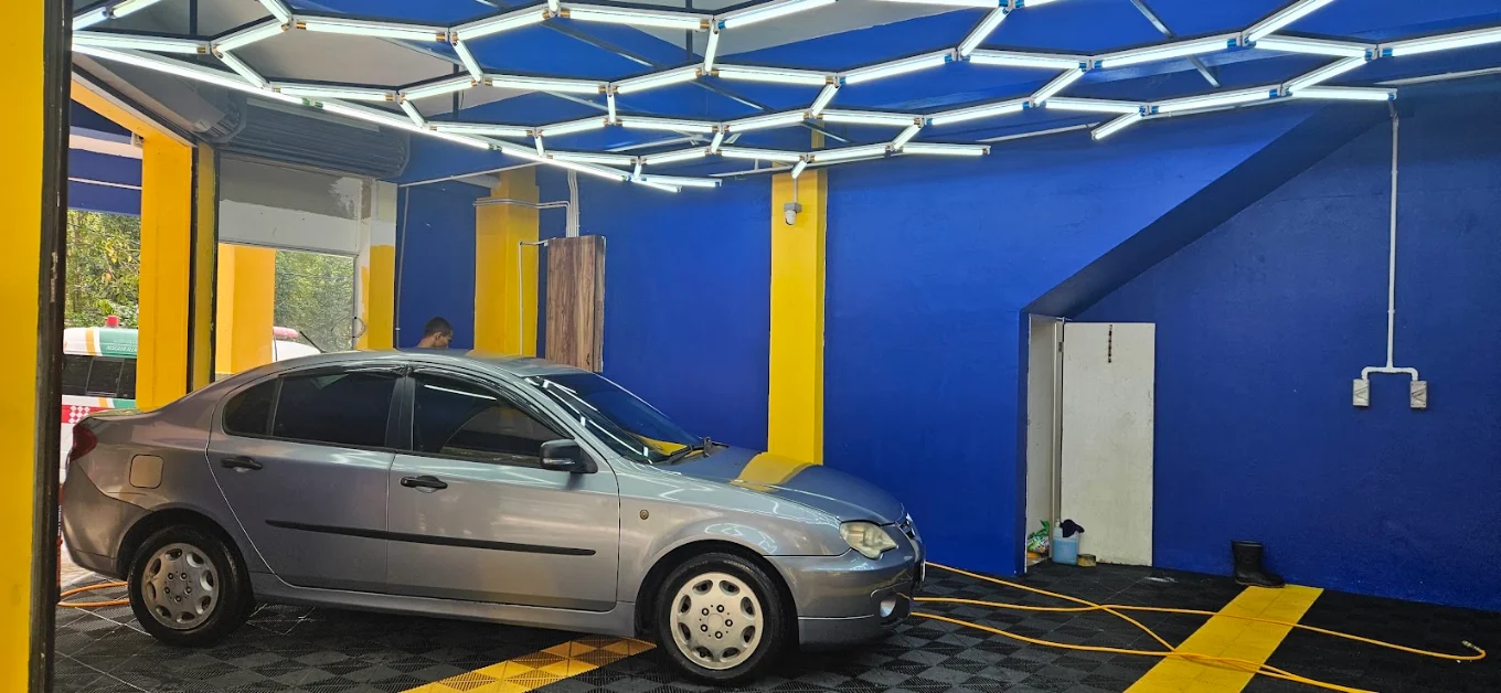 A car parked under the hexagonal LED light rig in the wash bay